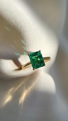 a green ring sitting on top of a white cloth