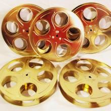 four golden reels with holes in them