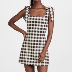 a woman wearing a black and white checkered dress