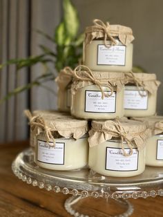 several candles are stacked on top of each other in glass containers with twine bows