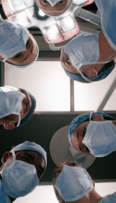 several doctors in scrubs are looking up at the camera