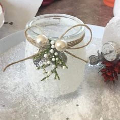 two mason jars decorated with christmas decorations on top of a white tablecloth covered tray