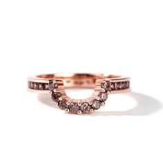 a rose gold ring with two rows of diamonds on it, set against a white background