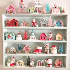 a white shelf filled with lots of christmas figurines on top of each other