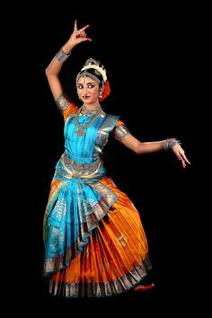 a woman in an orange and blue dress dancing