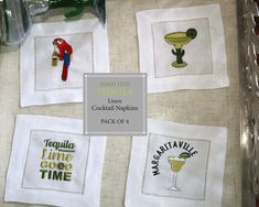 four embroidered cocktail napkins are on display