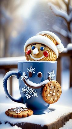 a cup with some cookies in it and a smiling face on the inside is surrounded by snow