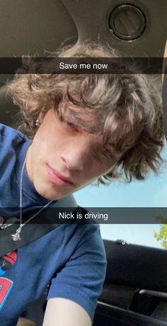 a young man sitting in the driver's seat of a car