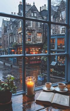 an open book sitting on top of a table next to a window