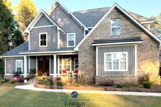 a large gray brick house with lots of windows on the front and side of it