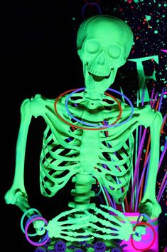 a skeleton with neon lights on it's body and arms, holding a cup