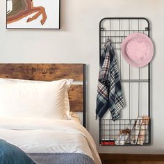 a bedroom with a bed, hat rack and pictures on the wall