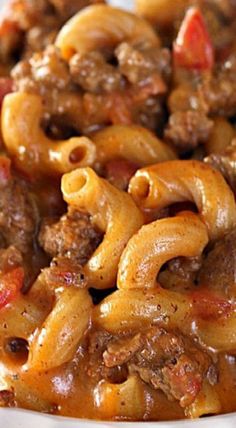 a white plate topped with pasta and meat