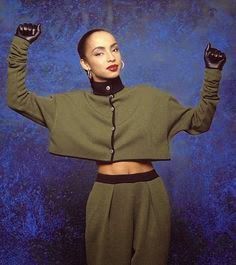 an instagram photo of a woman with her hands in the air, wearing green pants and crop top