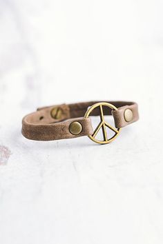 a bracelet with a peace sign on it sitting on top of a white countertop