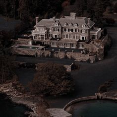 an aerial view of a large house with water in the foreground