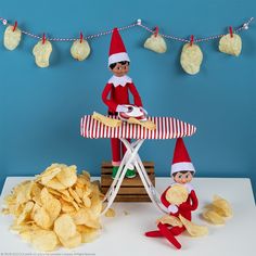 two elfs sitting at a table with potato chips