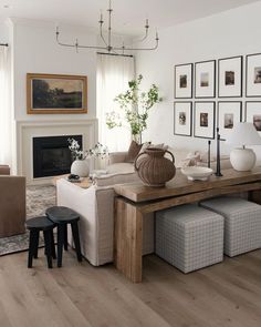 a living room filled with furniture and pictures on the wall above it's fireplace