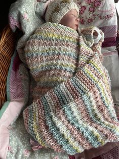 a baby wrapped in a knitted blanket