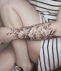 a woman's arm with flowers on it and the words, curio per tattooing