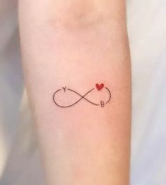 a small tattoo on the arm of a woman with an infinite love heart in it