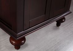 a close up of a bathroom vanity with dark wood cabinetry and silver flooring