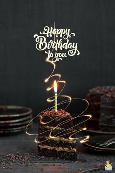 a piece of chocolate cake with a lit candle on it that says happy birthday to you