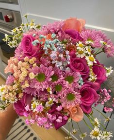 a woman holding a bouquet of flowers in her hand