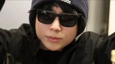 a young man wearing sunglasses and a beanie on top of his head with the word adidas written on it