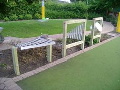 there is a bench made out of wood and some plants in the back yard area