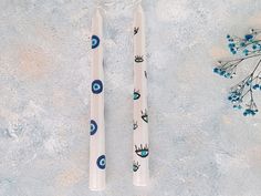 two toothbrushes with designs on them sitting next to each other near a plant