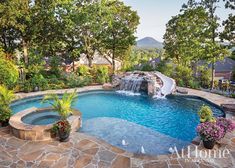 an outdoor swimming pool with waterfall in the middle and stone steps leading up to it