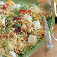 a plate full of rice and vegetables next to a glass of wine