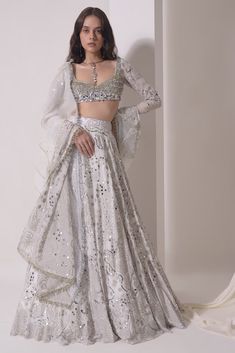 Luxury Blouse Piece With Sheer Dupatta For Festivals, Luxury Choli With Sheer Dupatta And Long Sleeves, White And Silver Lehenga, Luxury Silver Blouse Piece With Cutdana, Luxury Formal Choli With Sheer Dupatta, Luxury Long Sleeve Lehenga For Diwali, Luxury Silver Party Wear Lehenga, Luxury White Traditional Wear With Sequins, Luxury Silver Traditional Wear With Dupatta