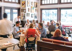 a group of people sitting at tables in a restaurant