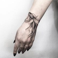 a woman's hand with a tattoo on it and water flowing down the arm