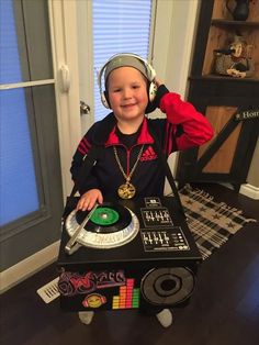 a young boy wearing headphones sitting in front of a record player