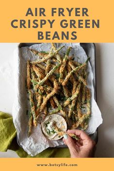 air fryer crispy green beans on a tray with dipping sauce in the middle