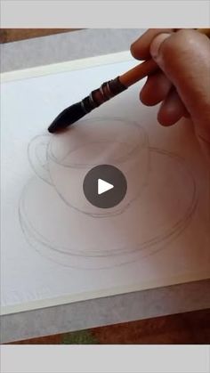 someone is drawing something on paper with a brush