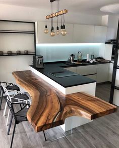 a modern kitchen with black counter tops and white cabinets, an island bench in the middle