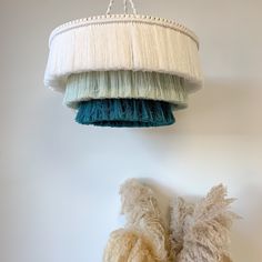 two teddy bears sitting under a hanging light fixture in a room with white walls and flooring