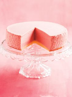 a pink cake sitting on top of a glass plate