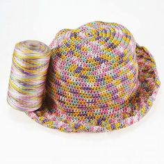 a multicolored hat with spools of thread next to it