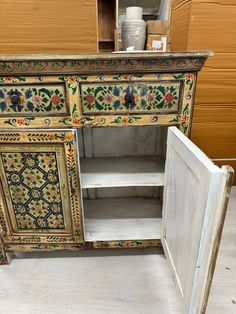 an ornate painted cabinet with doors open