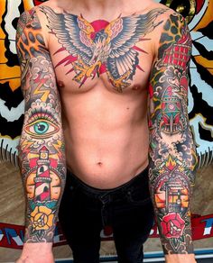 a man with lots of tattoos on his arm and chest is standing in front of a wall