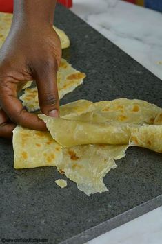 someone is making tortillas on a counter top with their fingers pointing at them