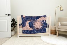 a baby crib with a blue and pink sun and moon design on the cover