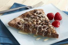 a piece of chocolate pie on a plate with raspberries