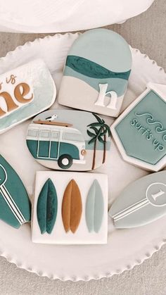 decorated cookies are arranged on a plate with the words love is in the air and surfboards