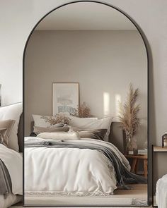 a bedroom with an arched bed frame and white linens on the bed, along with pillows and blankets